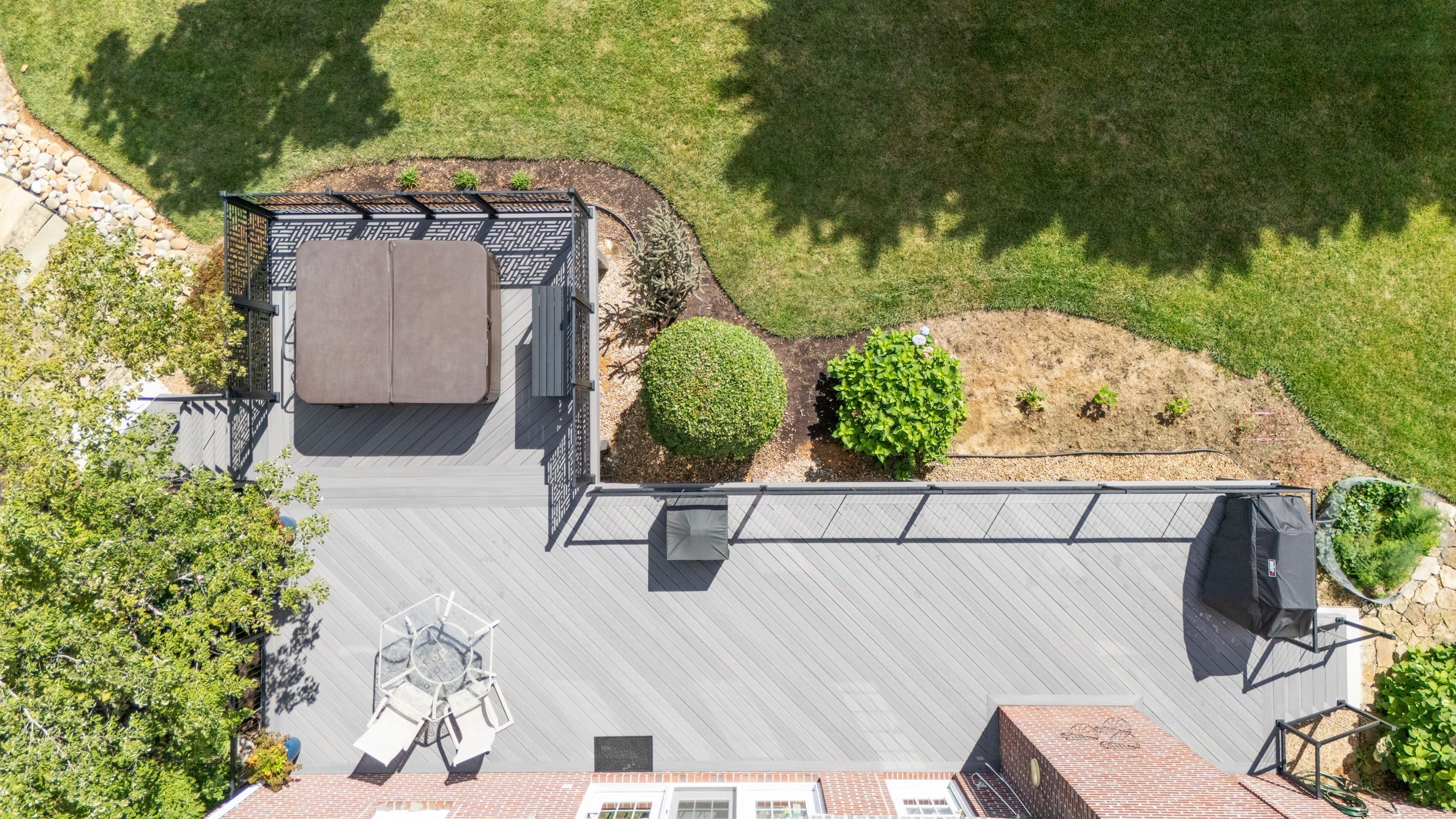 Top-down aerial of the Wilshire deck layout showing the hot tub, privacy screens, and gray composite decking