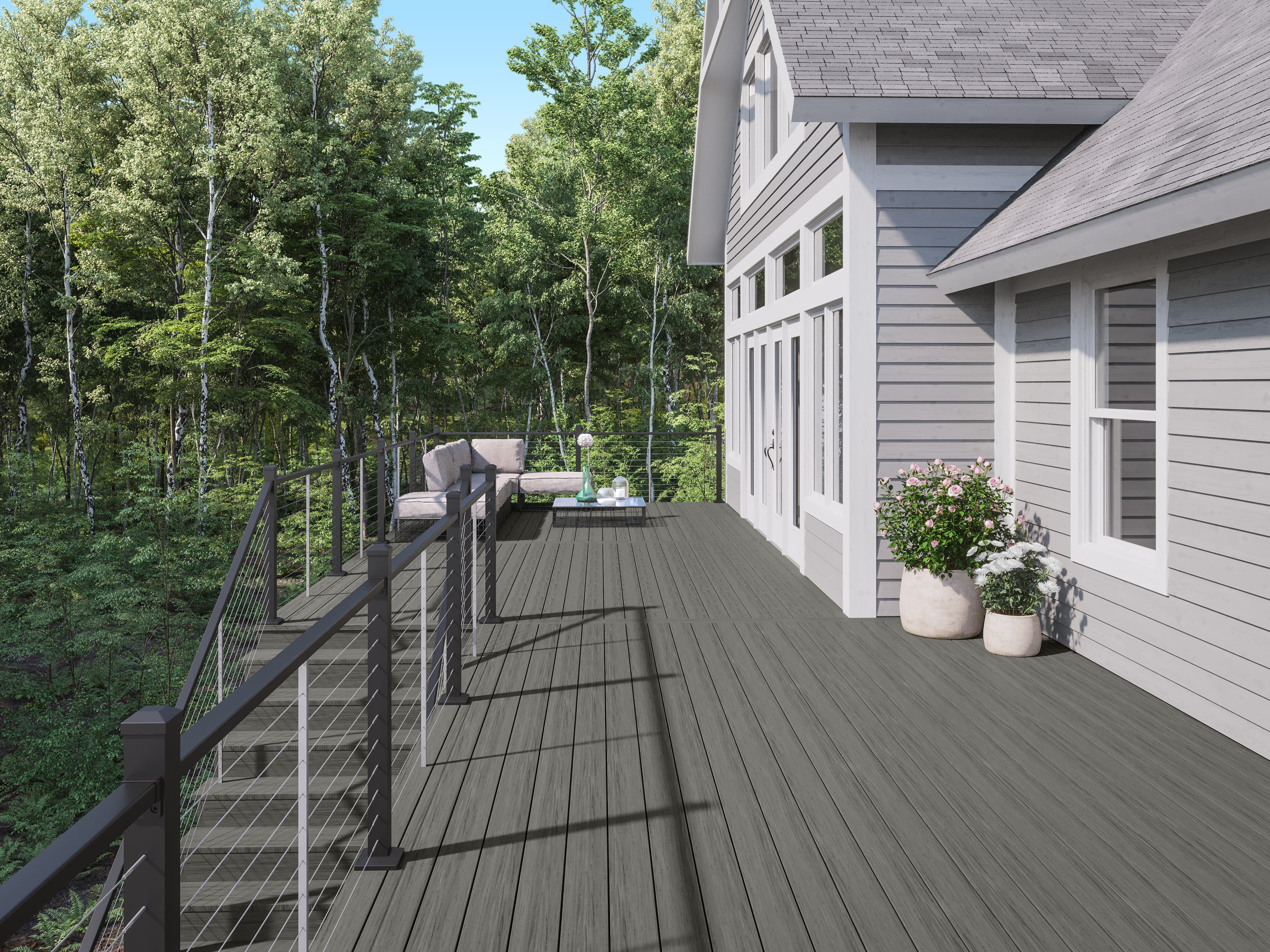 Deckorators Voyage Sierra decking with textured black ALX Contemporary cable railing on a modern gray house
